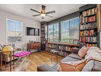 Cozy living room features a ceiling fan, built-in bookshelves, large windows, and comfortable seating at 10180 Delray Beach Ave # 202, Las Vegas, NV 89129