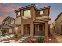 Charming two-story home with stucco exterior, covered porch, and landscaped front yard under a colorful sky at 2199 Timescape Ct, Las Vegas, NV 89123