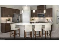 Modern kitchen boasts stainless steel appliances, dark wood cabinetry, and a large center island with barstool seating at 2607 Regency Cove Ct # Lot 11, Las Vegas, NV 89121