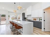Modern kitchen features a large island with seating, stainless steel appliances, and stylish pendant lighting at 4176 Demoline Cir, Las Vegas, NV 89141