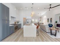 Open-concept kitchen with waterfall island, stainless steel appliances and pendant lighting at 4176 Demoline Cir, Las Vegas, NV 89141