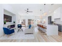 Open-concept living room boasts modern fireplace, ceiling fan, and seamless flow into kitchen and dining area at 4176 Demoline Cir, Las Vegas, NV 89141