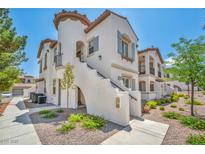 Charming two-story home featuring a unique staircase and landscaped front yard with colorful flowers at 50 Aura De Blanco St # 2104, Henderson, NV 89074