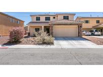 Charming two-story home with a tile roof, stone accents, and a well-manicured front yard at 6052 Puesta Del Sol St, North Las Vegas, NV 89081