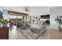 Spacious living room featuring an oversized sectional sofa, and an open layout to the kitchen at 7115 Calvert Cliffs St, North Las Vegas, NV 89084