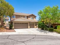 Inviting two-story home featuring a three-car garage and desert landscaping at 10612 Gum Tree Ct, Las Vegas, NV 89144