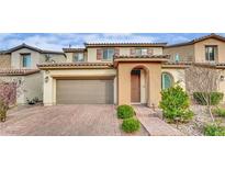 Charming two-story home featuring a brick driveway, arched entry and tidy front landscaping at 12816 Alcores St, Las Vegas, NV 89141
