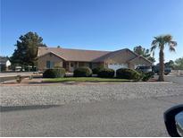 Charming single-story home featuring a tile roof, desert landscaping, and an attached three-car garage at 1571 Princeton Cir, Pahrump, NV 89060