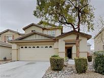 Charming two-story home featuring a well-maintained front yard with mature tree and an attached two-car garage at 209 Copper Pine Ave, North Las Vegas, NV 89031