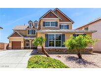 Charming two-story home featuring tan siding, gray shutters, and well-maintained landscaping at 2521 Cattrack Ave, North Las Vegas, NV 89081