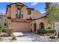 Charming two-story home with a tan stucco exterior, tiled roof, and well-manicured landscaping at 2851 Glistening Grove Ave, Henderson, NV 89052