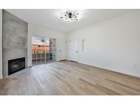 Bright living room featuring wood-look floors, a modern fireplace, and sliding glass doors to a balcony at 3318 N Decatur Blvd # 1107, Las Vegas, NV 89130