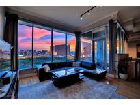 Stunning living room with a city view, floor-to-ceiling windows and modern black leather sectional at 360 E Desert Inn Rd # 1803, Las Vegas, NV 89109