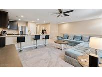 Spacious open-concept living room featuring bar seating and a comfortable sectional sofa at 4559 Dover Straight St, Las Vegas, NV 89115