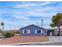 Charming single-story home showcasing a simplistic desert landscape and a driveway with covered parking at 4629 San Cir, Las Vegas, NV 89120