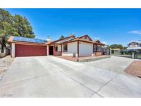 Charming single-story home featuring solar panels, a spacious driveway, and an attached two-car garage at 5876 Tippin Dr, Las Vegas, NV 89130