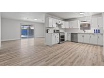 Modern kitchen features white cabinets, stainless steel appliances, and wood-look flooring at 6229 Cromwell Ave, Las Vegas, NV 89107