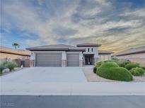 Beautiful single-story home featuring a three-car garage, desert landscaping, and a neutral color palette at 7225 Millerbird St, North Las Vegas, NV 89084