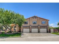 Charming two-story home with a three-car garage, stone accents, and manicured lawn at 7761 Cowboy Trl, Las Vegas, NV 89131