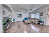 Spacious living room with vaulted ceilings, hard wood floors, and a comfortable, neutral-toned sofa at 8567 Little Fox St, Las Vegas, NV 89123