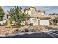 Charming two-story home with a desert landscaped front yard and a driveway leading to a two-car garage at 9718 Camino Capistrano Ln, Las Vegas, NV 89147