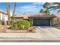 Charming single-story home featuring a low-pitch tile roof and well-maintained desert landscaping in a sunny setting at 1803 Candle Bright Dr, Henderson, NV 89074