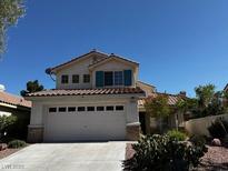 Charming home featuring a two-car garage, tile roof, and desert landscaping at 2419 Pebble Springs Ct, Henderson, NV 89074