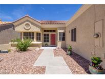Charming single-story home featuring a red front door, desert landscaping and a tiled roof at 2420 Desert Butte Dr, Las Vegas, NV 89134