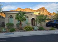Charming single-story home with desert landscaping, mountain views, and a blue truck in the driveway at 26 Costa Tropical Dr, Henderson, NV 89011