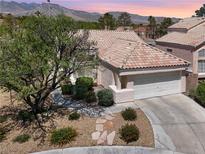 Charming single-story home with a tile roof, mature landscaping, and a two-car garage at 3053 Anchor Chain Dr, Las Vegas, NV 89128