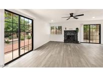 Bright living room with modern floors, sliding glass doors, and a stone fireplace at 3484 Nightflower Ln # 2, Las Vegas, NV 89121