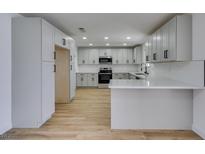Updated kitchen featuring white cabinets, stainless steel appliances, and a breakfast bar at 3986 Belleville Ave, Las Vegas, NV 89121