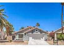 Charming single-story home with a well-maintained front yard and a two-car garage at 6961 Ray Charles Ln, Las Vegas, NV 89119