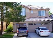 Two-story home with a two-car garage and lush green landscaping in a well-maintained neighborhood at 9440 Grenville Ave, Las Vegas, NV 89134