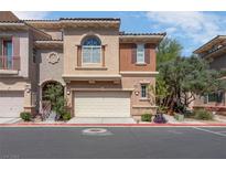 Charming townhome with a two-car garage and landscaped front, offering curb appeal and convenience at 9975 Sand Key St, Las Vegas, NV 89178