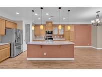 Spacious kitchen featuring an island, stainless steel refrigerator, and ample cabinet space for storage at 9975 Sand Key St, Las Vegas, NV 89178