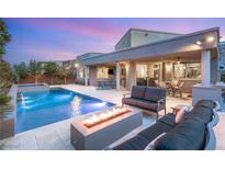 Stunning backyard featuring a pool, spa, fire pit, and comfortable seating, perfect for outdoor relaxation and entertainment at 10482 Calico Terrace Ave, Las Vegas, NV 89135