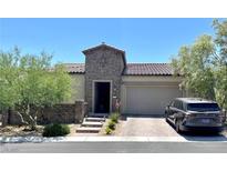 Charming single-story home with a stone facade, tiled roof, and a paved driveway leading to an attached two-car garage at 119 Colantonio Ct, Las Vegas, NV 89138