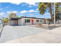 Charming single-story home featuring a carport, xeriscaping, and a vibrant red front door at 1417 Dogwood Ave, North Las Vegas, NV 89030