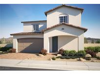 Two-story home featuring a two-car garage, an arched entryway, and professionally landscaped desert-style curb appeal at 320 Della Pergola Pl, Henderson, NV 89015