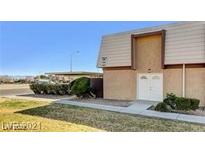 Two-story home featuring a covered parking area, a well-maintained lawn, and a symmetrical facade with a double-door entrance at 3441 Villa Way, Las Vegas, NV 89120