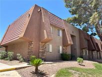 A view of the condo complex with landscaped grounds and decorative stone facade at 5383 Indian River Dr # 327, Las Vegas, NV 89103