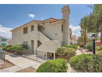 Inviting two-story condo showcasing lovely landscaping and a pathway leading to the entrance at 605 Devonhall St # 201, Las Vegas, NV 89145
