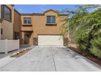 Charming townhouse showcasing a two-car garage and desert landscaping at 6325 Orions Tool St, North Las Vegas, NV 89031