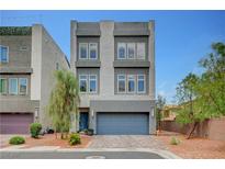 Contemporary two-story home featuring a grey stucco facade, a two-car garage, and a well-manicured front yard with brick pavers at 7756 Seville Estates Ct, Las Vegas, NV 89113