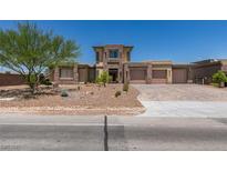 A grand two-story home showcasing a three-car garage, desert landscaping, and unique architectural elements at 7998 W Ford Ave, Las Vegas, NV 89113
