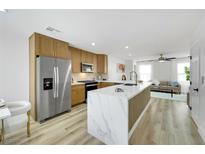 Modern kitchen with stainless steel appliances and a large marble island that opens to the living room at 9078 Hilverson Ave, Las Vegas, NV 89148