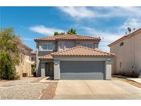 Two-story home featuring a red tile roof, two-car garage, neutral stucco, and low-maintenance desert landscaping at 10162 Lemon Thyme St, Las Vegas, NV 89183
