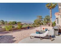 Landscaped backyard with golf course view features a lounge chair for relaxation and enjoyment of the outdoors at 10504 Button Willow Dr, Las Vegas, NV 89134