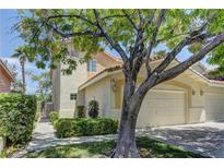 Charming townhouse showcasing a well-kept lawn and inviting two-car garage, with mature trees providing ample shade at 108 Broken Rock Dr, Henderson, NV 89074